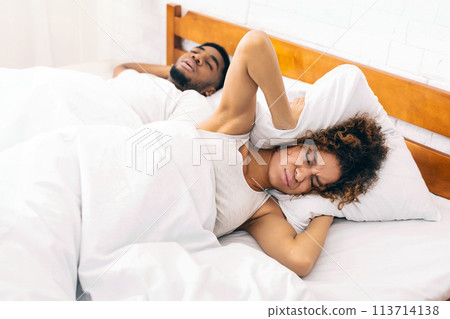 Tired and annoyed woman of her boyfriend snoring 113714138