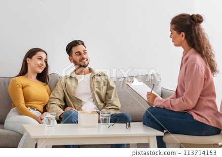 Couple smiling during counseling session, happy with results Couple smiling during counseling session, happy with results 113714153