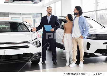 Car salesman discussing with indian couple Car salesman discussing with indian couple 113714240