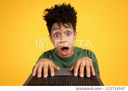 Shocked person looking over laptop screen 113714347