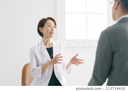 A female doctor examining a patient A female doctor examining a patient 113714410