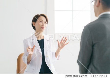 A female doctor examining a patient A female doctor examining a patient 113714411