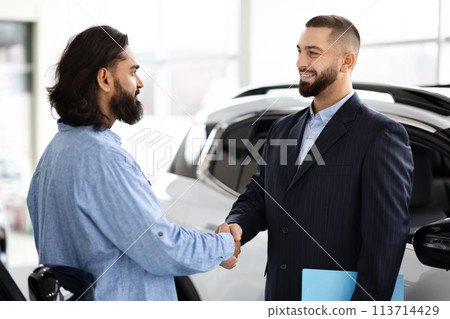 Two men shaking hands in car dealership Two men shaking hands in car dealership 113714429
