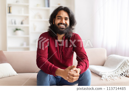 Smiling man sitting on couch in a home 113714485