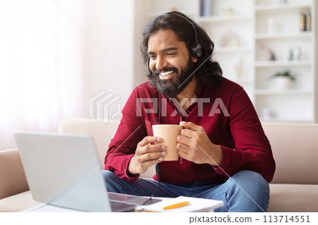 Man with mug enjoying work on laptop 113714551
