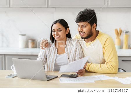 Couple engaging with finances on laptop at kicthen Couple engaging with finances on laptop at kicthen 113714557