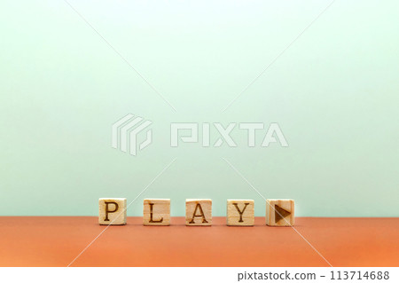 A front view of a white background with blocks with the word PLAY and a play mark lined up on a red floor 113714688