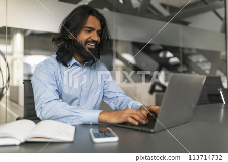 Smiling professional typing on a laptop 113714732