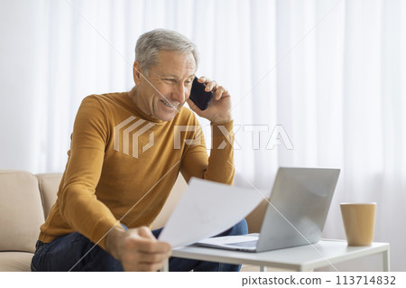 Elderly man analyzing documents with a phone call Elderly man analyzing documents with a phone call 113714832