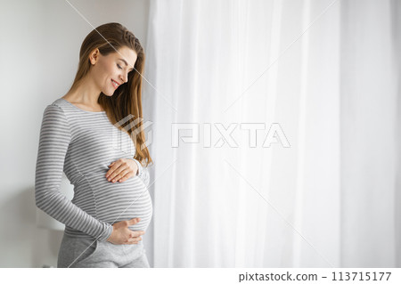 Pregnant lady smiling with closed eyes Pregnant lady smiling with closed eyes 113715177