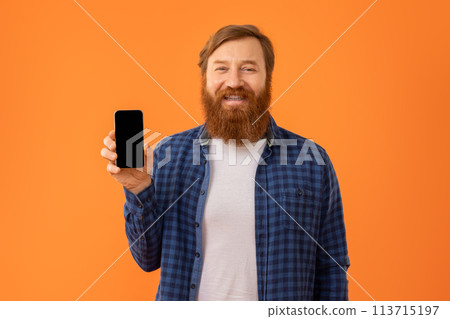 Positive redhaired bearded man showing his smartphone blank screen, studio Positive redhaired bearded man showing his smartphone blank screen, studio 113715197