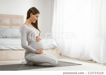 Pregnant woman practicing prenatal yoga 113715228