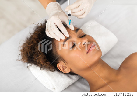 African american woman receiving facial injection treatment African american woman receiving facial injection treatment 113715233