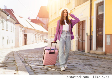 Traveler in summer hat with suitcase in European street 113715234