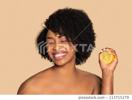 Joyful black woman with lemon, natural beauty zest 113715279