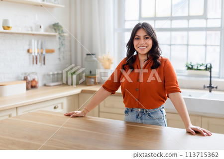 Smiling woman in modern kitchen interior at home Smiling woman in modern kitchen interior at home 113715362