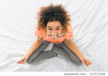 African-american woman meditating on the bed, top view African-american woman meditating on the bed, top view 113715385