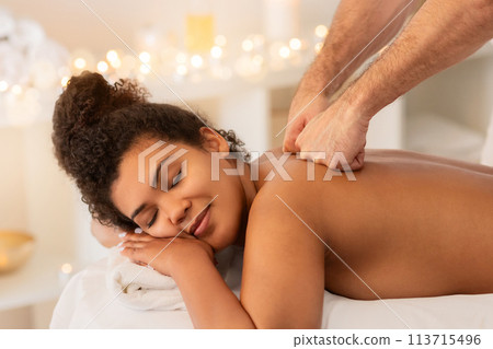 Content lady receiving shoulder massage at spa Content lady receiving shoulder massage at spa 113715496