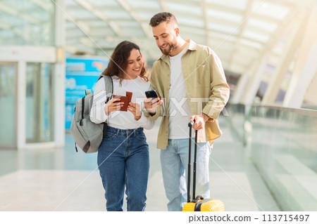Enthusiastic couple with phone and suitcase 113715497