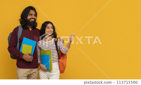 Two students holding books on yellow background 113715500