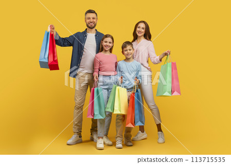 Family with shopping bags smiling on yellow background Family with shopping bags smiling on yellow background 113715535