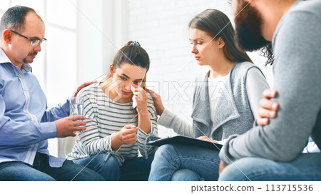 Understanding people calming crying woman during group session meeting in rehab Understanding people calming crying woman during group session meeting in rehab 113715536