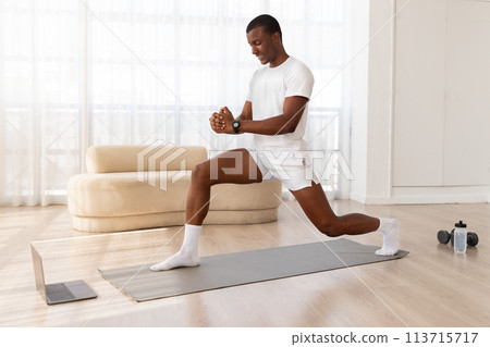 Man doing a lunge in a bright room 113715717