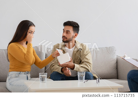 Man comforting woman on couch with tissues Man comforting woman on couch with tissues 113715735