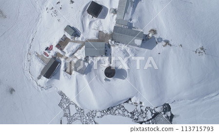 Aerial drone view flight. Vernadsky Base, ocean, mountains. Fast. The station settlement on the Antarctica continent surrounded snow covered mountains and ice ocean. Harsh conditions. Aerial drone view flight. Vernadsky Base, ocean, mountains. Fast. The station settlement on the Antarctica continent surrounded snow covered mountains and ice ocean. Harsh conditions. 113715793