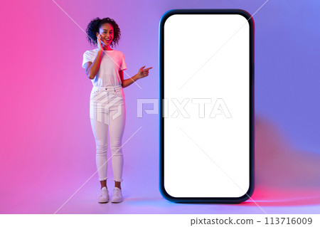 Woman pointing at giant white blank phone screen 113716009