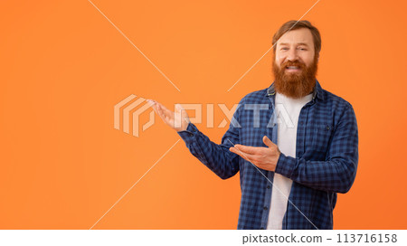 Smiling Man With Red Hair Gesturing Showing Copy Space, Studio Smiling Man With Red Hair Gesturing Showing Copy Space, Studio 113716158
