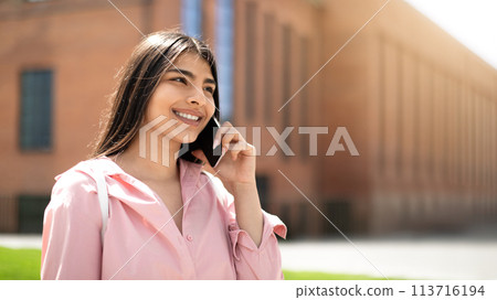 Smiling student on a phone call in sunshine Smiling student on a phone call in sunshine 113716194