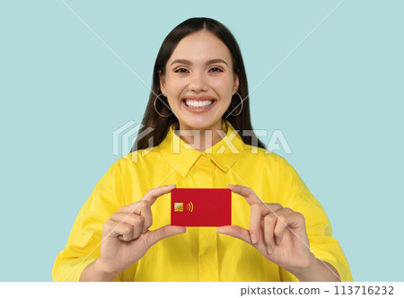 Easy banking concept - happy young woman with credit card at blue backdrop 113716232