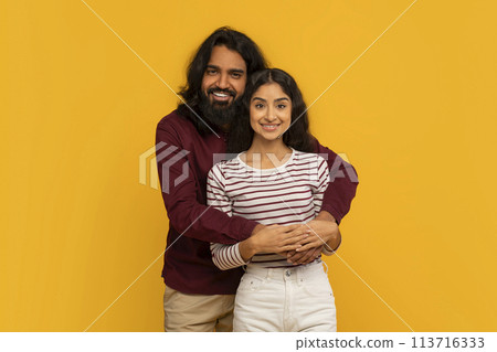 Man and woman standing together on a yellow background Man and woman standing together on a yellow background 113716333