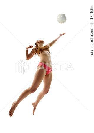 Female beach volleyball player in sport uniform in jump serve ball in motion against white background. 113716392