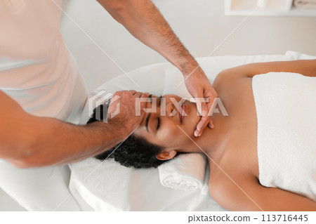 Male masseur giving face massage to woman 113716445