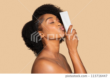 Black woman loving her skincare, kisses product tube 113716447