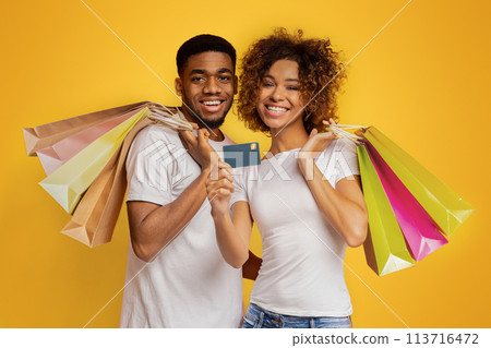 Young black couple with shopping bags and credit card Young black couple with shopping bags and credit card 113716472