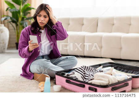 Worried middle eastern woman checking her phone 113716475