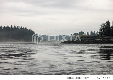 Majestic clouds hover over a vast lake framed by towering mountains 113716852