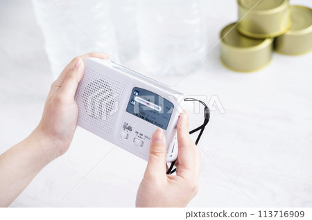 Woman's hand holding a disaster prevention radio Woman's hand holding a disaster prevention radio 113716909