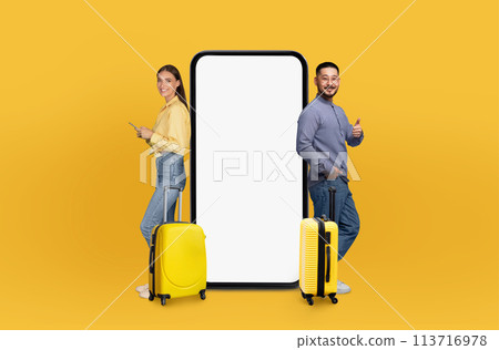 Couple standing with luggage by phone with app 113716978