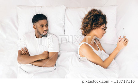 Woman reading message on phone in bed 113717116