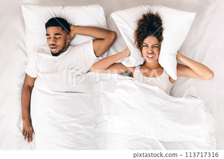Tired and annoyed woman of her boyfriend snoring Tired and annoyed woman of her boyfriend snoring 113717316