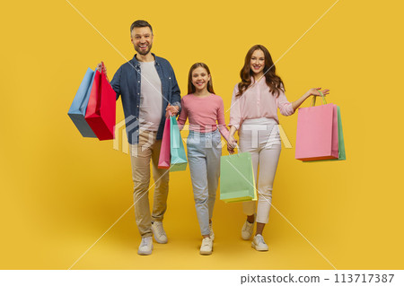 Happy family walking with shopping bags on yellow background 113717387