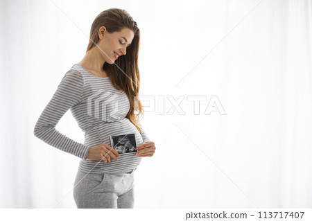 Pregnant woman with ultrasound photo 113717407