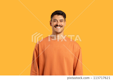 Smiling millennial in orange smiling at camera Smiling millennial in orange smiling at camera 113717621