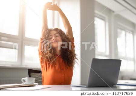 Woman stretching with a smile during work break 113717629