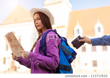Concerned traveler checking map and wallet theft 113717650