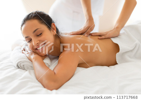 Happy lady relaxes during rejuvenating massage lying on spa bed Happy lady relaxes during rejuvenating massage lying on spa bed 113717668